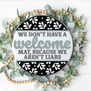 Painted version of wooden sign kit saying We don't have a welcome mat because we aren't liars.